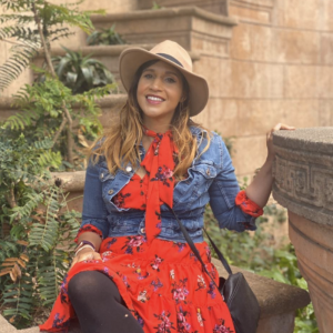 A woman with a sunhat and flowery dress in front of the Palace of Fine Arts. 